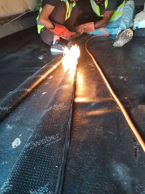 Seam of a bitumen membrane being sealed with a torch • #1 Waterproofing Company in Dubai & UAE • #1 Waterproofing Company in Dubai & UAE Seam of a bitumen membrane being sealed with a torch